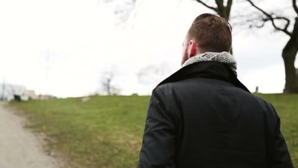 Man lopen in een park buiten — Stockvideo