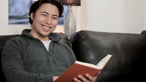 Hombre disfrutando de un buen libro en su casa — Vídeo de stock