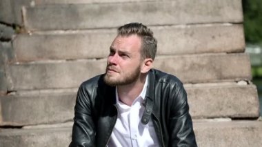 Yakışıklı adam oturuyor aşağı dışarıda