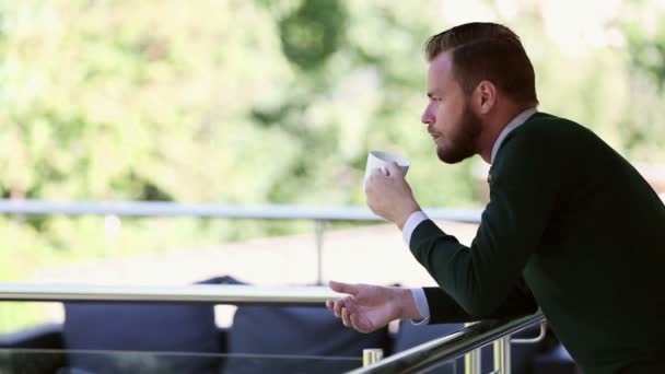 Pensive man standing outside with a coffee mug — Stock Video