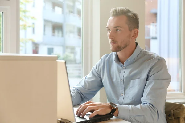 Handsome student sitting by his laptop — Stock Photo, Image