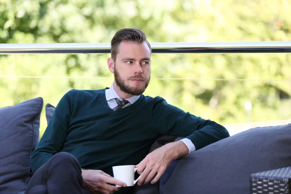 Businessman sitting down outdoors — Stock Photo, Image