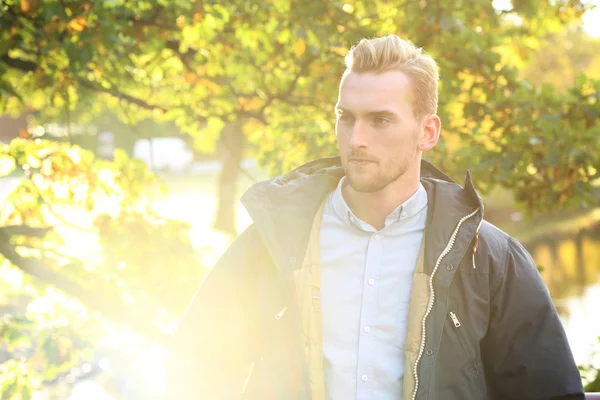 Trendy man die op een brug met lens flare — Stockfoto