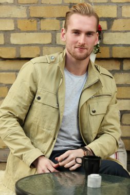 Yakışıklı adam kahve içiyor.