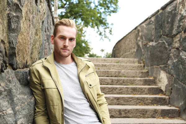 Fashionable man leaning outside