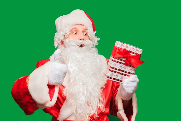 Kerstman houden mooi verpakt kerstcadeau geïsoleerd op groen gekleurde achtergrond — Stockfoto