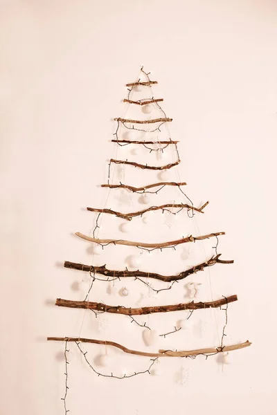 Alternatif ahşap ağaç süslemeli Noel ağacı duvarda asılı duruyor..