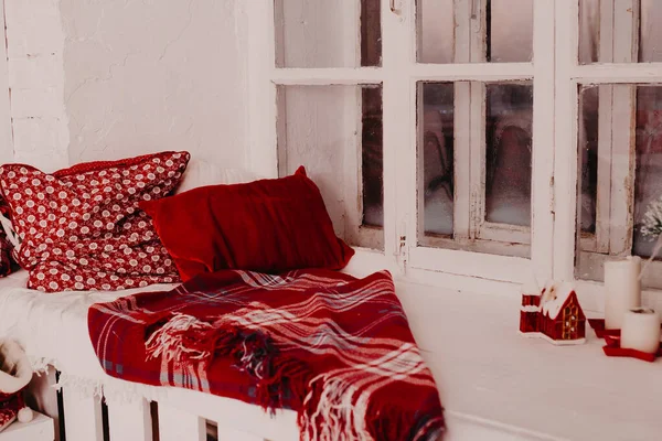 Travesseiros e xadrez tricotado quente em um peitoril da janela, um canto acolhedor, um peitoril de janela acolhedor — Fotografia de Stock