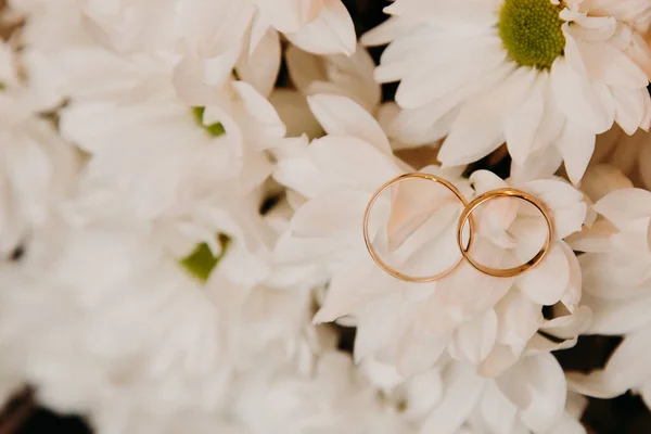 Wedding rings on the bouquet the bride on background of wedding dress — Stock Photo, Image