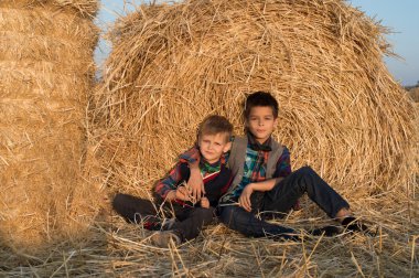 Çocuk haystacks oturmak