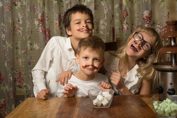 Barn är nära choklad fontän — Stockfoto