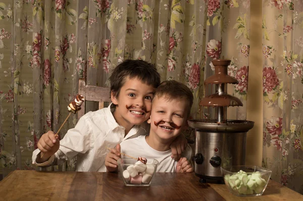 子供たちがチョコレートの噴水の近く ストック画像