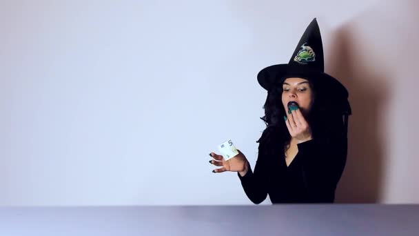 Čarodějnice jí mozky. Žena oblečená halloween se zelenými nehty, euro má růžový sliz — Stock video