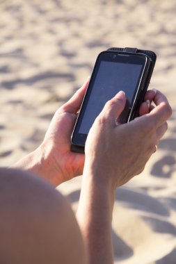 sahilde elinde telefon
