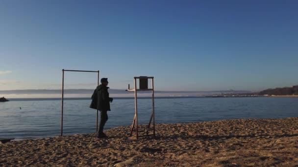 Jovem treinamento de inverno na praia fazendo pull ups pela manhã para resolução 2021 — Vídeo de Stock