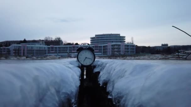 Reloj congelándose en una orilla del mar. Concepto: Temperaturas cayendo. — Vídeo de stock