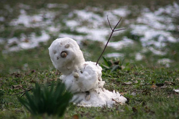 Schneemann schmilzt mit grünem Gras. Konzept: Frühling — Stockfoto