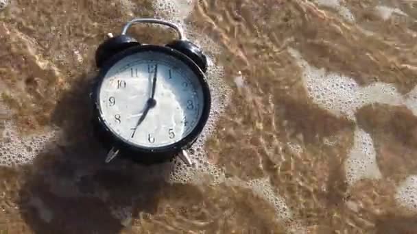 Reloj despertador salpicando en el agua de la playa — Vídeo de stock