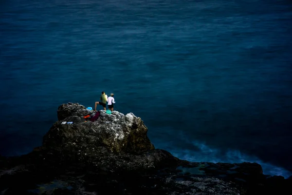 男と女は海に極端なナイトロック釣りを練習します。 — ストック写真