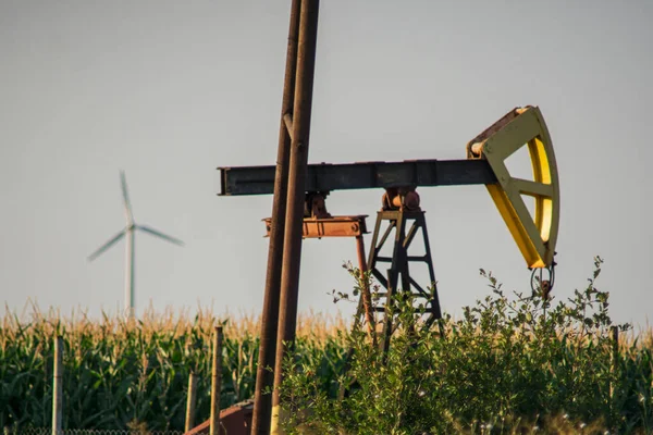 POMPA DI OLIO VERSUS WIND TURBINE NEL TERRITORIO. CONCEPT: VERSUS OIL ENERGIA VERSA — Foto Stock