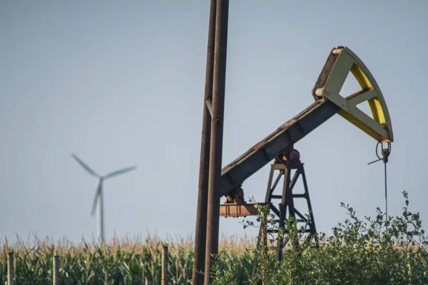 OLEJ PUMP VERSUS VÍN TURBINE V ZÁKLADĚ. KONCEPT: GREEN ENERGY VERSUS OIL — Stock fotografie