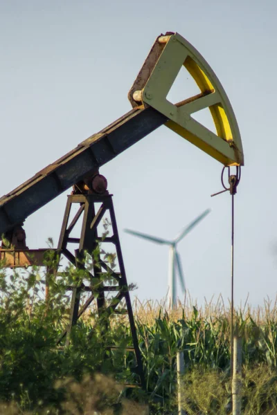 OLEJ PUMP VERSUS VÍN TURBINE V ZÁKLADĚ. KONCEPT: GREEN ENERGY VERSUS OIL — Stock fotografie