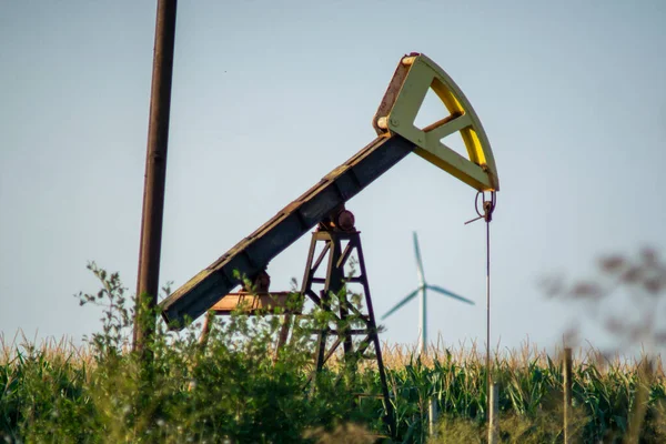 OLEJ PUMP VERSUS VÍN TURBINE V ZÁKLADĚ. KONCEPT: GREEN ENERGY VERSUS OIL — Stock fotografie