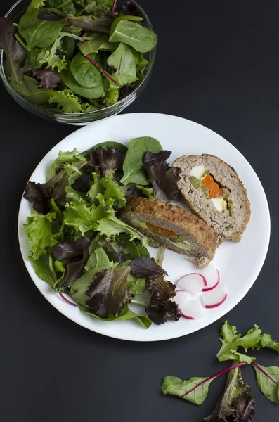 Фаршированный мясной рулет и зеленый салат — стоковое фото