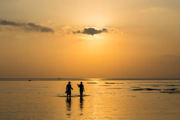 Silhouette coppia a piedi nel mare — Foto Stock