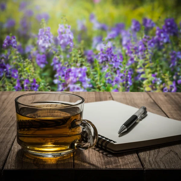 Forró tea, a notebook és a toll a fa tábla — Stock Fotó