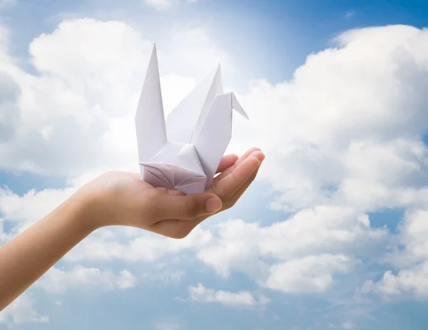 Hand holding bird paper origami