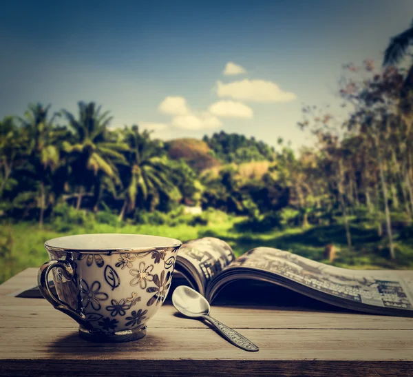 Taza de café con revista sobre mesa de madera —  Fotos de Stock