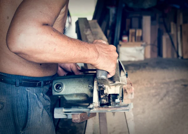 Carpinteiro segurando uma serra elétrica — Fotografia de Stock