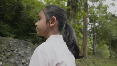 Orman parkına bakan Asyalı genç bir kızın etrafında dönüyorlar. Ormanda macera gezisi. Eko-turizm. Gezi gezisi. Tayland.