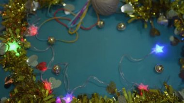 Masanın üzerine kırmızı kurdele bağlanmış bir hediye kutusunu koyan kadının elleri yanıp sönen ışık ve altın maddeyle süslenir. Yeni yıl ve Noel tatili için özel hediye.