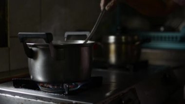 Mutfak kapağını kapatın. Kaynayan yeşil fasulyeleri, kepçeyle karıştıran yaşlı bir annenin elleriyle. Yemek pişirmekten duman yükseliyor.. 