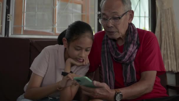 Äldre Farfar Lära Bedårande Barnbarn Att Använda Mobiltelefon App För — Stockvideo