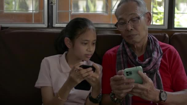 Adorável Neta Sentada Lado Seu Avô Idoso Usando Smartphone Móvel — Vídeo de Stock