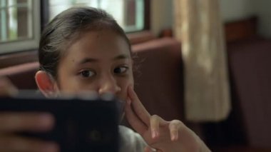 Komik, tapılası Taylandlı kız evde karantina sırasında cep telefonuyla fotoğraf çekmeyi ya da video çekmeyi seviyor..