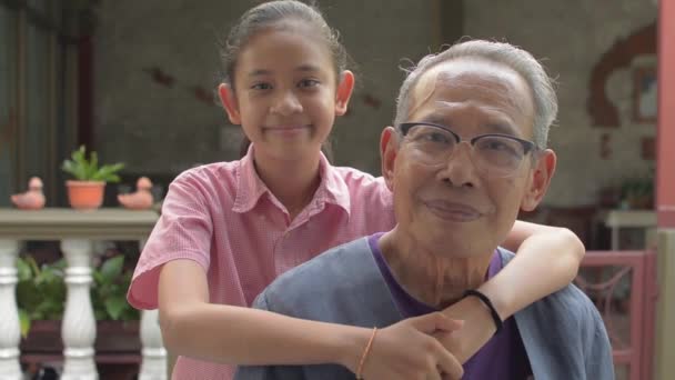 亚洲可爱的小孙女在家中摆姿势和看着相机时 高兴地拥抱着年迈的白发祖父 在两代人的时间里 与爱情结合在一起 健康的生活 — 图库视频影像