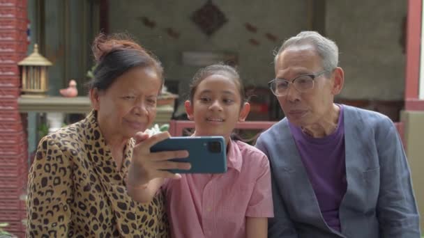 Glad Asiatisk Bedårande Flicka Sitter Bredvid Sina Äldre Morföräldrar Och — Stockvideo