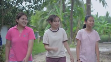 Keyifli üç Taylandlı genç kız köydeki patikada rahat rahat konuşup yürüyorlar. Sağlıklı genç kadın yaşam tarzınız kutlu olsun. Asyalı kardeşler..