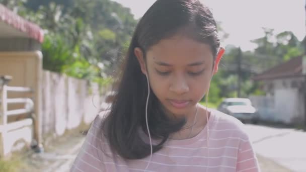 Asijské Dlouhé Vlasy Rozkošné Dívka Nosí Sluchátka Chodí Neuspěchaně Ulici — Stock video