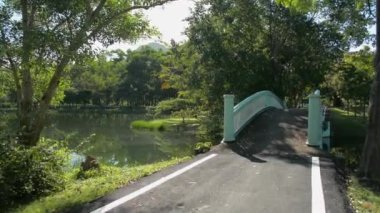 Spor kıyafetli bir kadınla hava manzarası sabah güneşinin altında parktaki eski beton köprüden geçerken çekildi. Sağlıklı bir yaşam tarzı. Kirlilikten arındırılmış çevre.