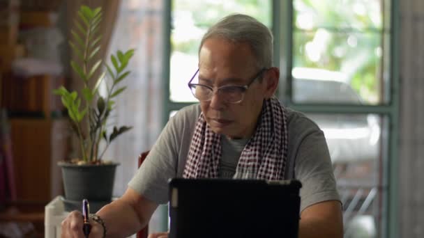Asiatique Senior Homme Robe Décontractée Écriture Sur Bloc Notes Regarder — Video