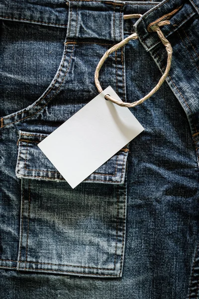 Біла листівка на зморщених джинсах — стокове фото
