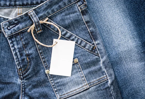 Біла листівка на блакитних джинсах — стокове фото
