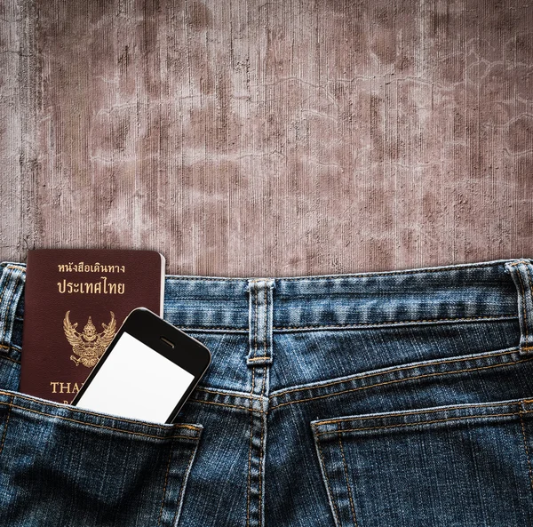 Calça jeans azul com celular e passaporte em um fundo de bolso — Fotografia de Stock