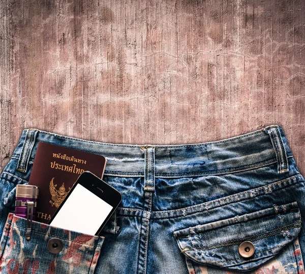 Голубые джинсы с мобильным телефоном, фонариком и паспортом в кармане — стоковое фото