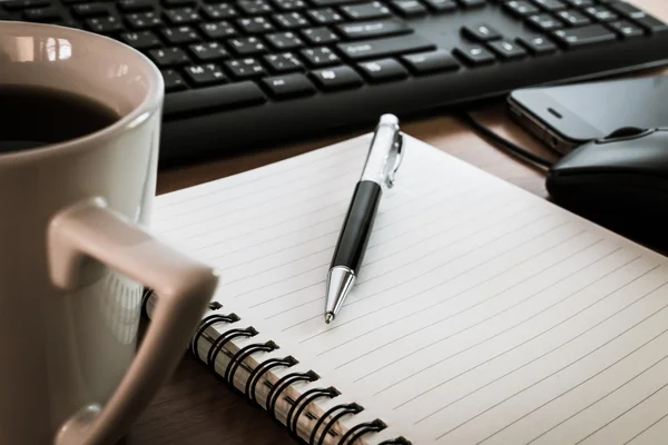 Ручка на ноутбуке с кофейной клавиатурой, мышкой и сотовым фоном — стоковое фото